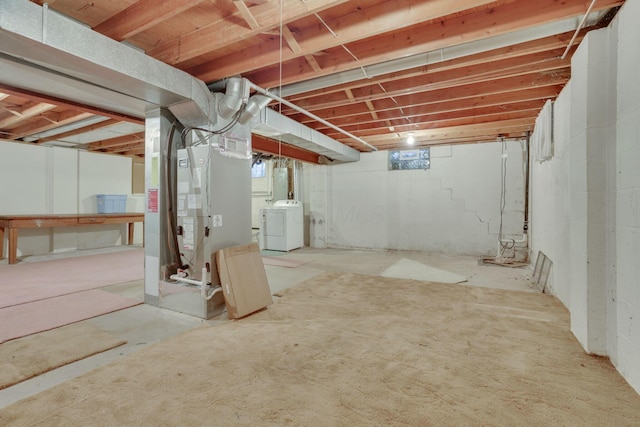 basement featuring heating unit and washing machine and clothes dryer