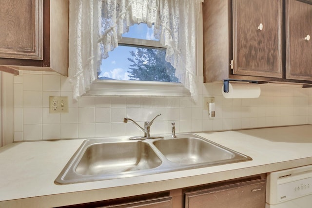 kitchen featuring tasteful backsplash, sink, and dishwasher