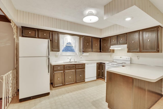 kitchen with white appliances, kitchen peninsula, sink, and decorative backsplash