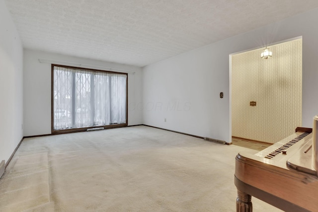 spare room with a textured ceiling and carpet