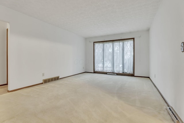 carpeted spare room with a textured ceiling