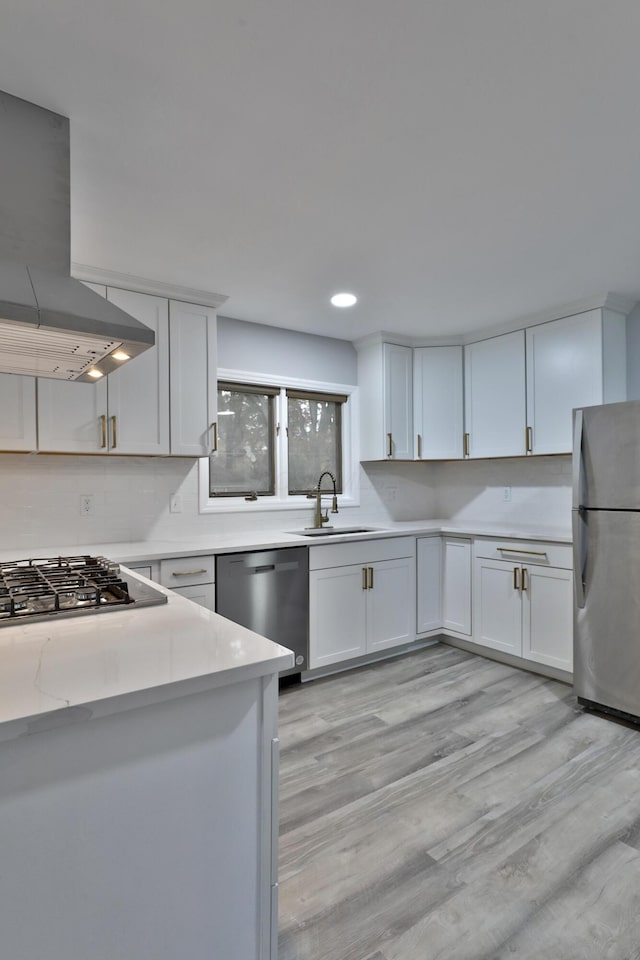 kitchen featuring stainless steel appliances, island exhaust hood, white cabinets, and light hardwood / wood-style floors