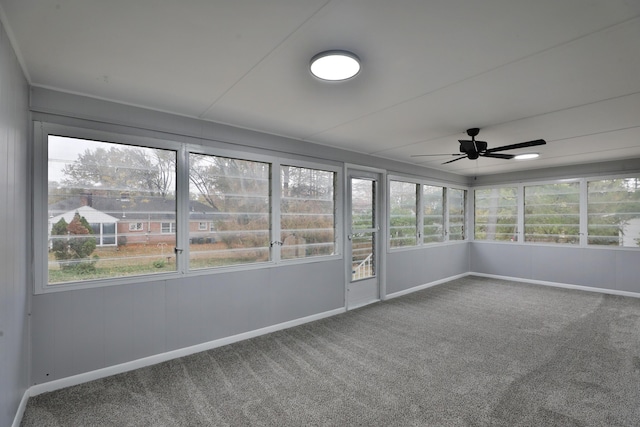 unfurnished sunroom featuring ceiling fan and a wealth of natural light