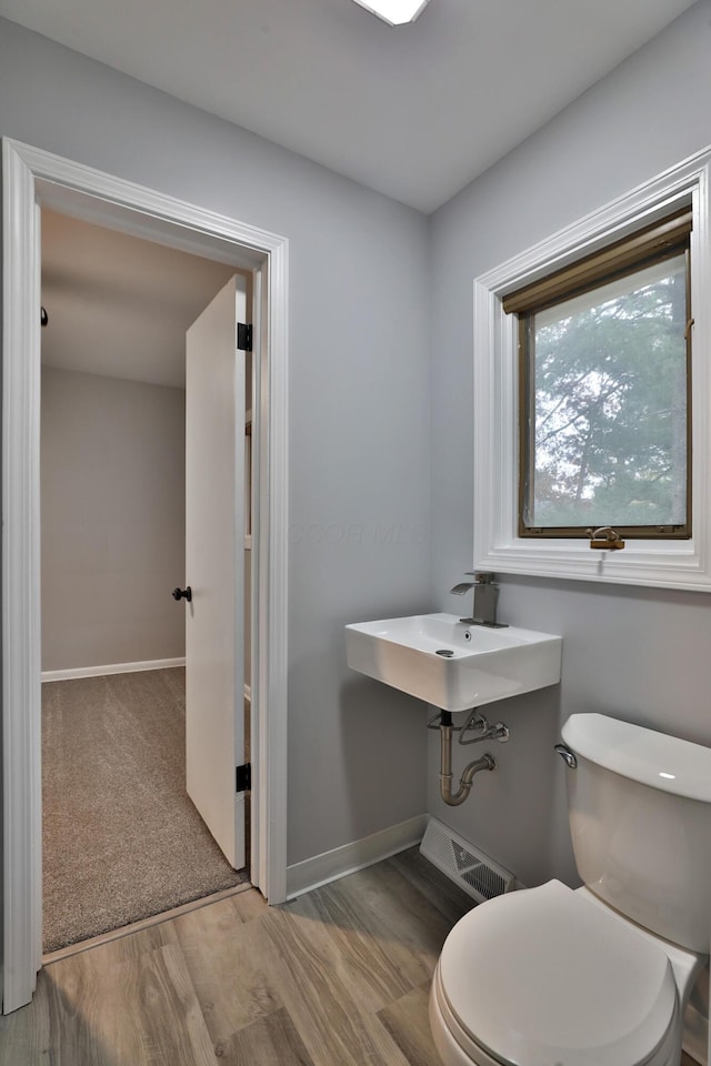 bathroom with sink, hardwood / wood-style floors, and toilet