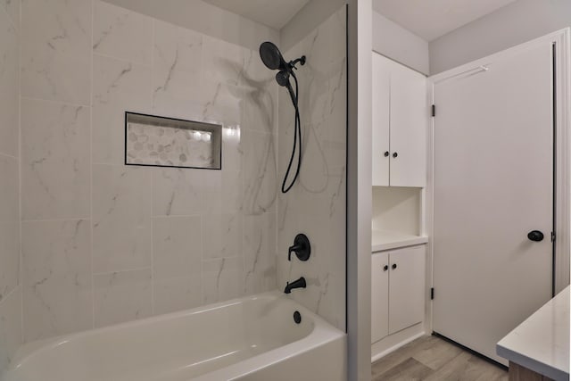 bathroom with tiled shower / bath combo, vanity, and hardwood / wood-style flooring