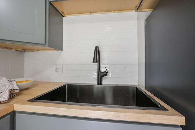 kitchen featuring backsplash, sink, and gray cabinetry