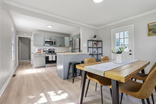 dining room featuring crown molding and light hardwood / wood-style floors