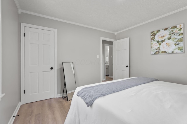 bedroom featuring ornamental molding, a textured ceiling, and light hardwood / wood-style flooring