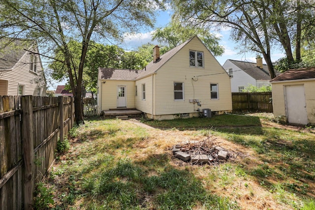 back of property featuring a lawn and an outdoor fire pit