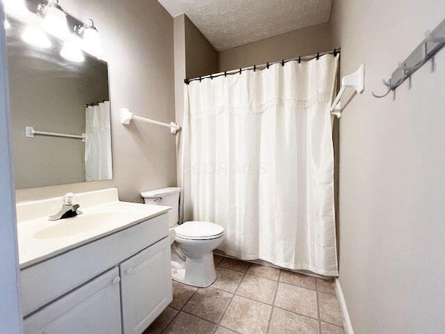 6155 Pelican Pointe Unit 103, Columbus, OH 43231 - bathroom with toilet, a textured ceiling, vanity, tile patterned floors, and curtained shower