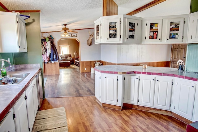 kitchen with white cabinetry, sink, light wood-type flooring, ceiling fan, and a textured ceiling