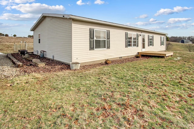 rear view of house with a wooden deck and a yard