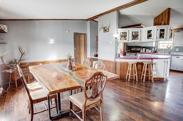 dining room with lofted ceiling, crown molding, dark hardwood / wood-style flooring, and a textured ceiling