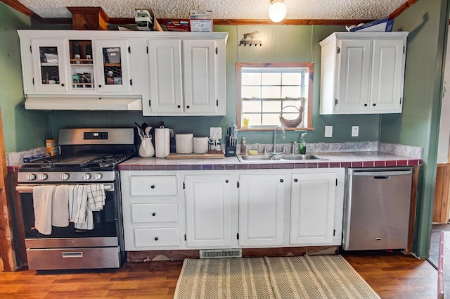 kitchen featuring stainless steel appliances, white cabinetry, sink, and dark hardwood / wood-style floors