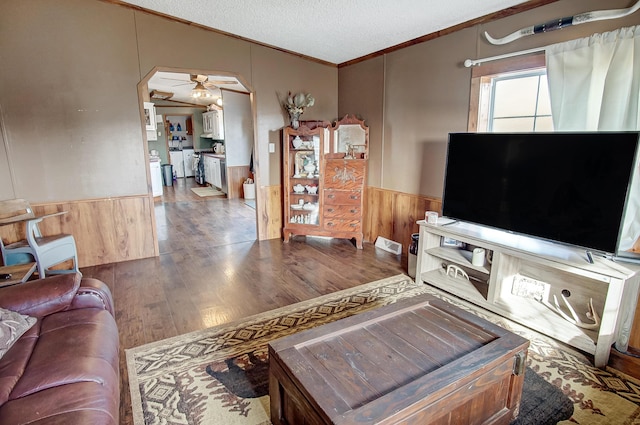 living room featuring lofted ceiling, crown molding, ceiling fan, hardwood / wood-style floors, and a textured ceiling