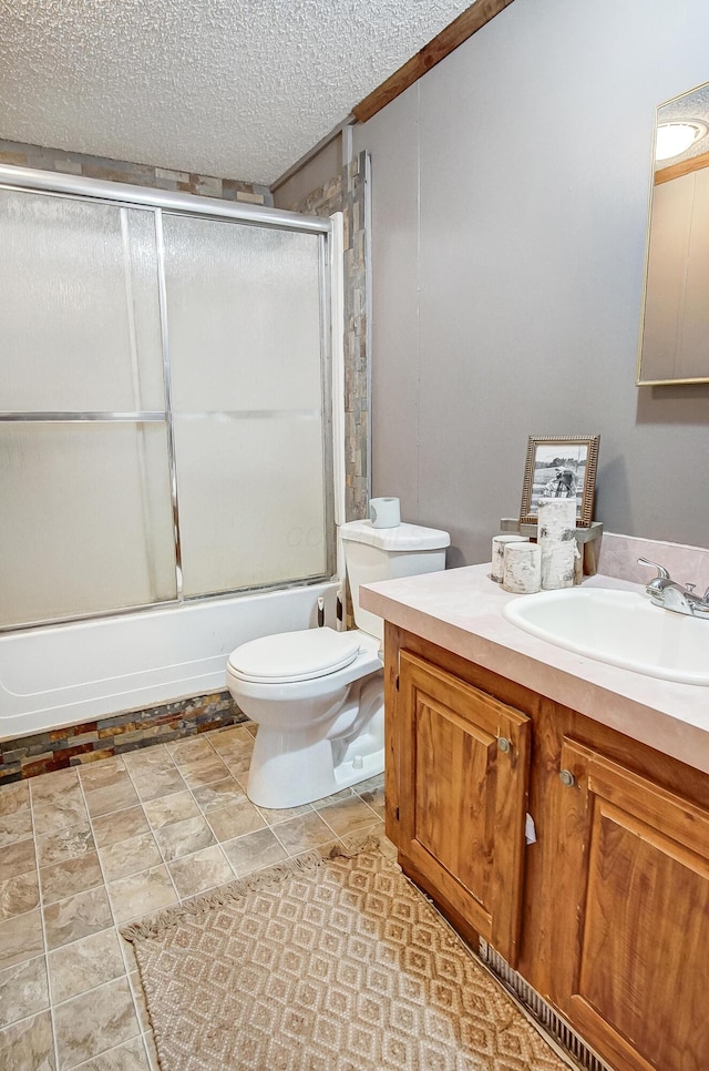 full bathroom with toilet, vanity, bath / shower combo with glass door, and a textured ceiling