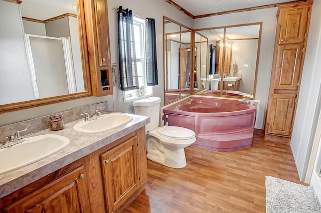 full bathroom featuring hardwood / wood-style flooring, vanity, ornamental molding, toilet, and a textured ceiling