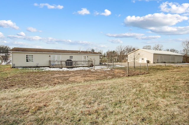 rear view of property with a wooden deck and a yard