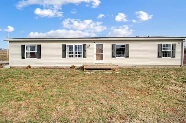 manufactured / mobile home featuring a wooden deck and a front lawn