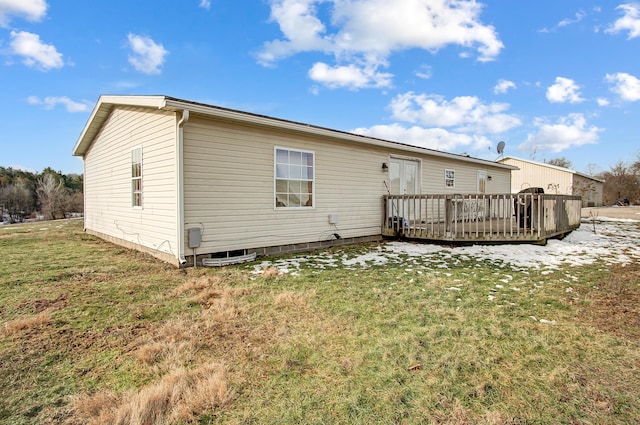 rear view of house with a wooden deck and a yard