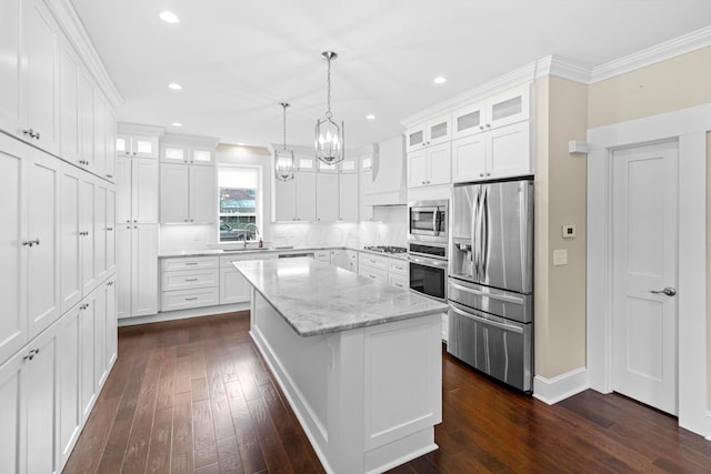 kitchen featuring white cabinetry, light stone counters, a center island, pendant lighting, and stainless steel appliances