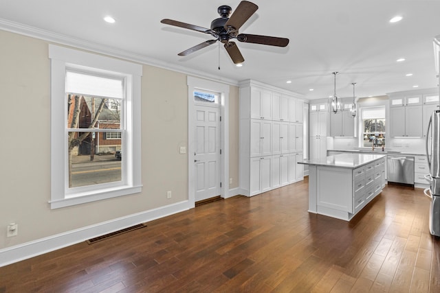 kitchen with pendant lighting, white cabinetry, a healthy amount of sunlight, and a kitchen island