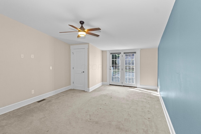 spare room featuring light colored carpet and ceiling fan