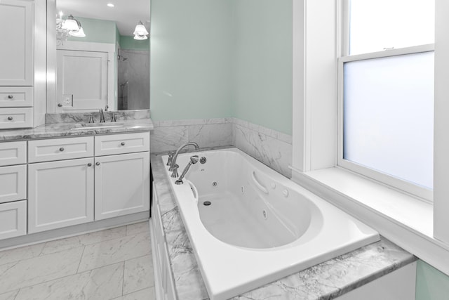 bathroom with vanity and tiled bath