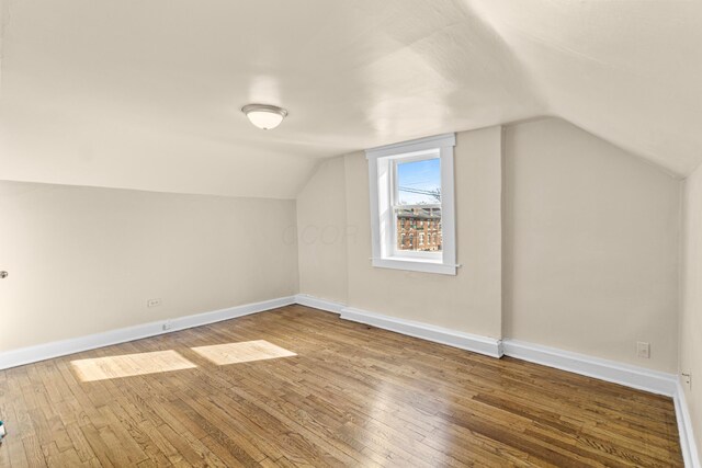 additional living space featuring hardwood / wood-style flooring and lofted ceiling