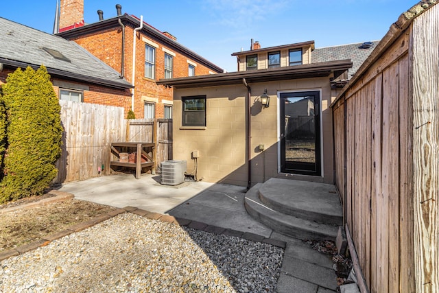 view of exterior entry featuring cooling unit and a patio