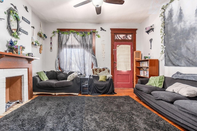 living room with a brick fireplace, hardwood / wood-style floors, and ceiling fan