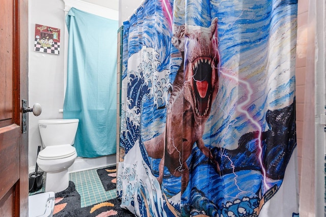 bathroom featuring a shower with shower curtain, tile patterned floors, and toilet