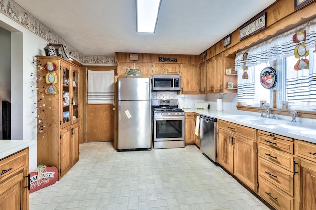 kitchen with stainless steel appliances, sink, and backsplash