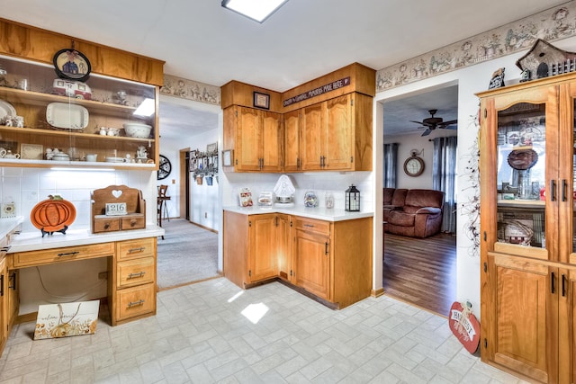 kitchen with built in desk, backsplash, and ceiling fan