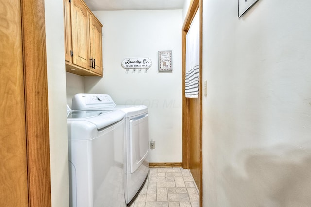 clothes washing area featuring cabinets and separate washer and dryer