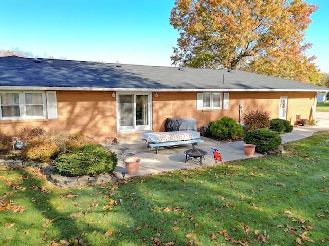 back of house featuring a yard, a fire pit, and a patio area