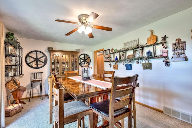 carpeted dining room featuring ceiling fan