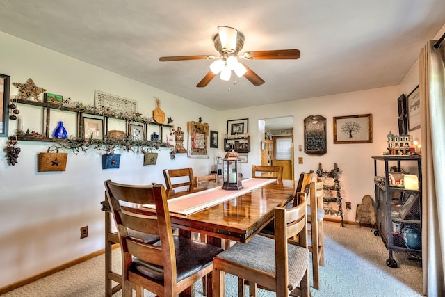 dining space featuring light colored carpet and ceiling fan