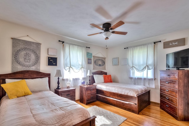 bedroom featuring multiple windows, ceiling fan, and light wood-type flooring