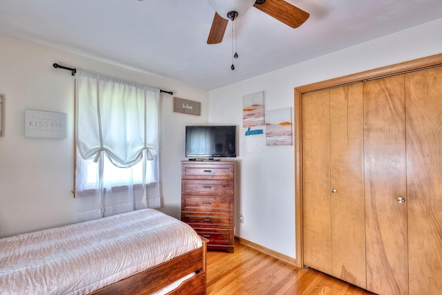 bedroom featuring ceiling fan, light hardwood / wood-style floors, and a closet