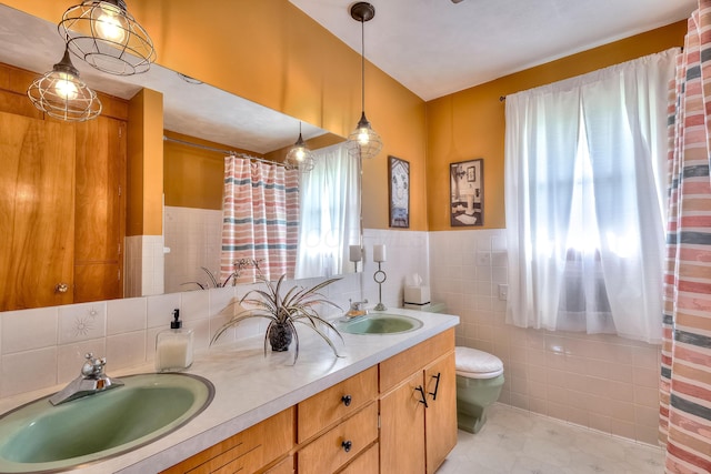 bathroom featuring vanity, tile walls, and toilet