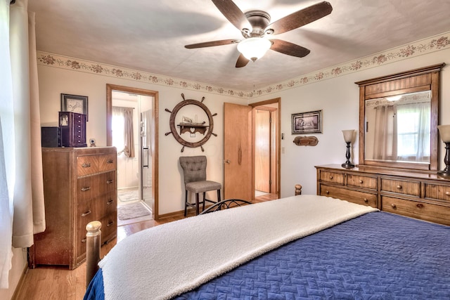 bedroom with hardwood / wood-style flooring, ceiling fan, and ensuite bath