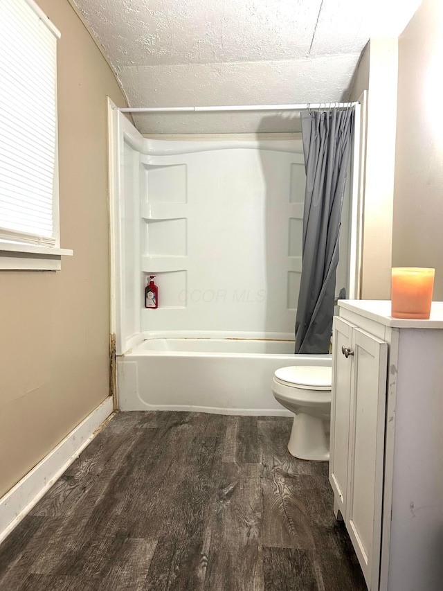 full bathroom featuring wood-type flooring, vanity, toilet, shower / bath combo, and a textured ceiling