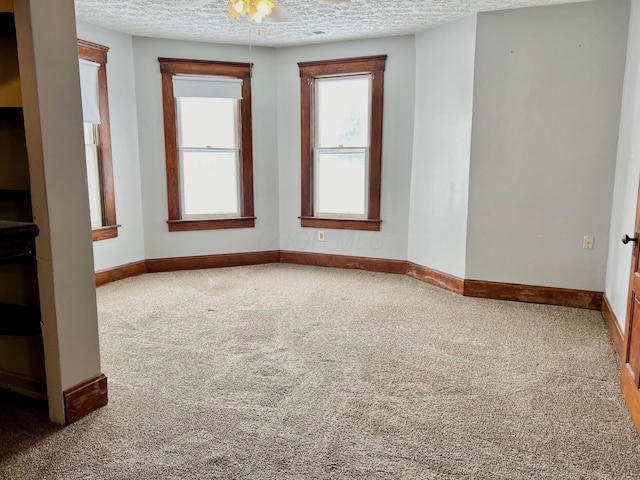 carpeted spare room with a textured ceiling