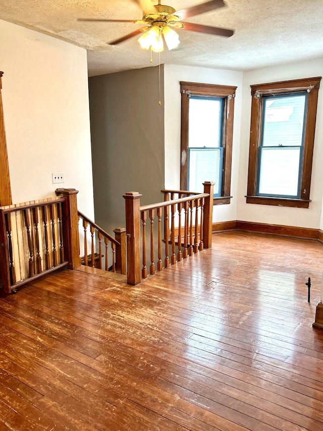 spare room featuring ceiling fan, hardwood / wood-style floors, and a textured ceiling