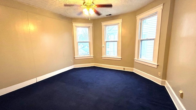 carpeted empty room with ceiling fan and a textured ceiling