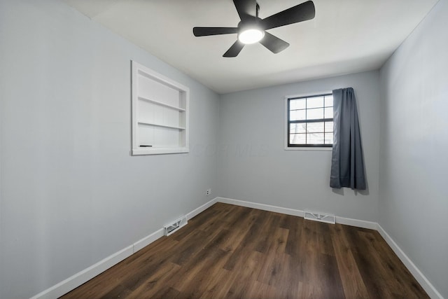 unfurnished room featuring built in shelves, ceiling fan, and dark hardwood / wood-style flooring