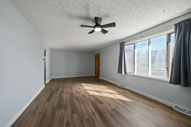 spare room with ceiling fan, dark hardwood / wood-style floors, and a textured ceiling