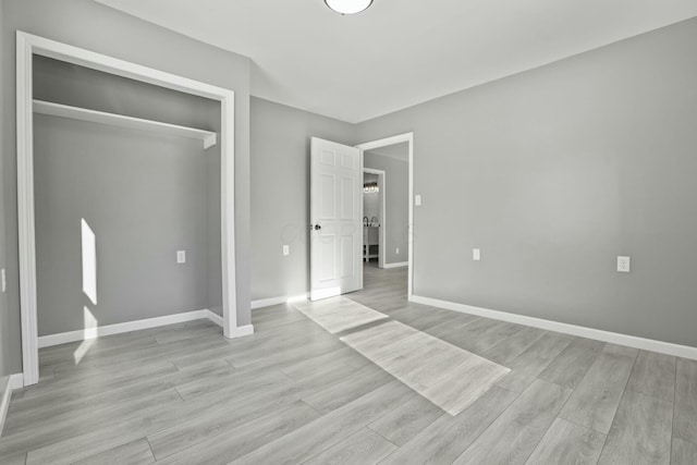 unfurnished bedroom featuring light hardwood / wood-style floors and a closet