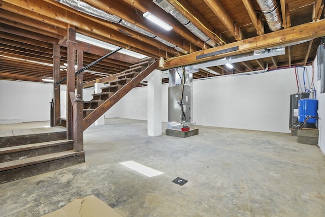 basement featuring baseboard heating, water heater, and heating unit